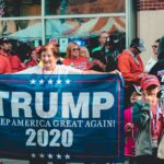 A crowded political rally in Wheeling, showcasing Trump supporters with banners and signs.