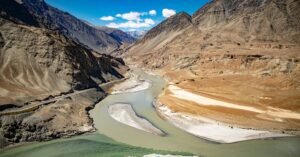 A breathtaking view of the Indus and Zanskar rivers converging surrounded by majestic Ladakh mountains.