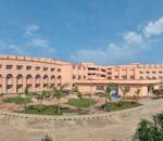 Large educational building with clear blue sky and landscaped grounds.